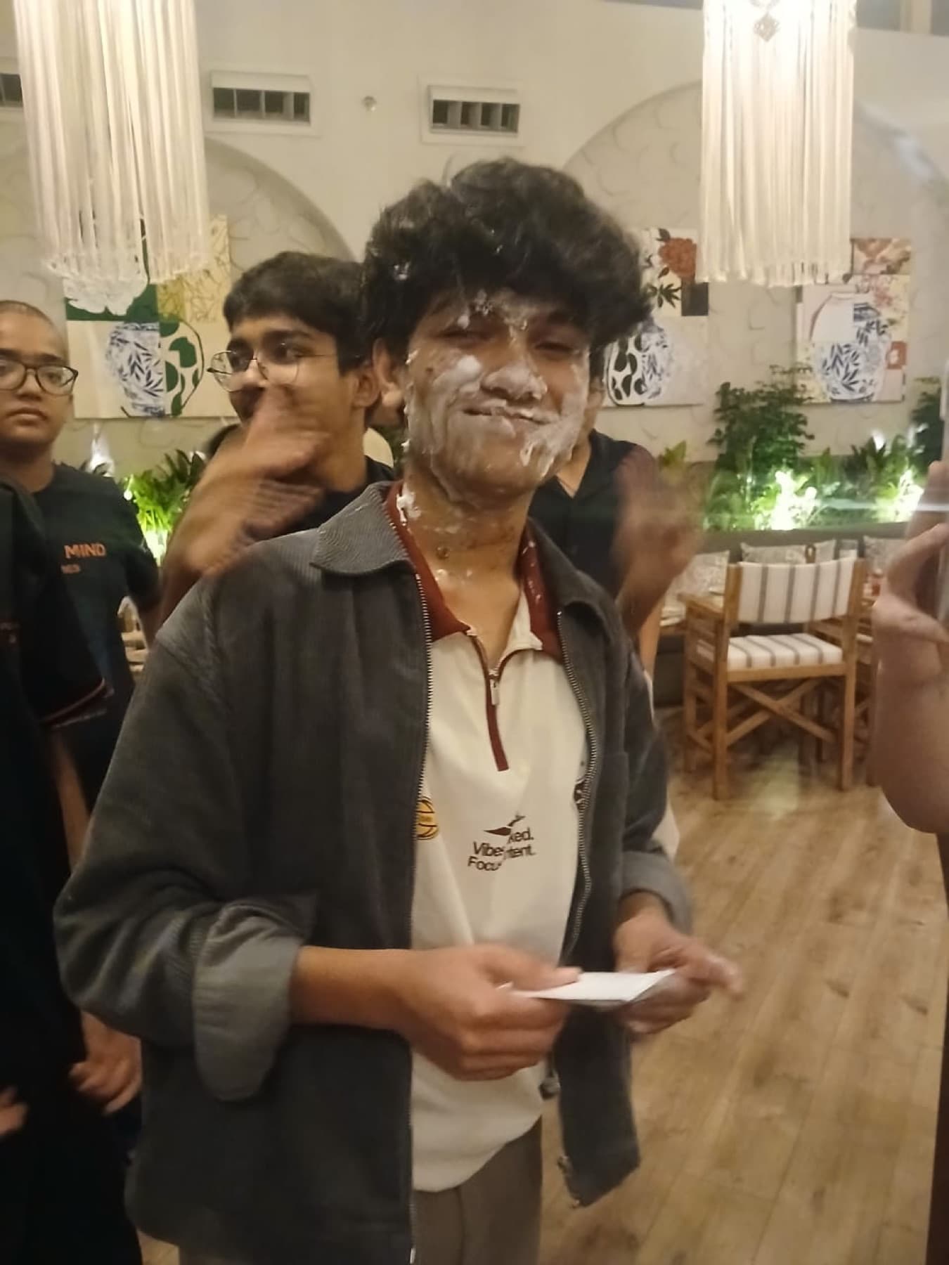 Darsh covered in cake at a birthday dinner