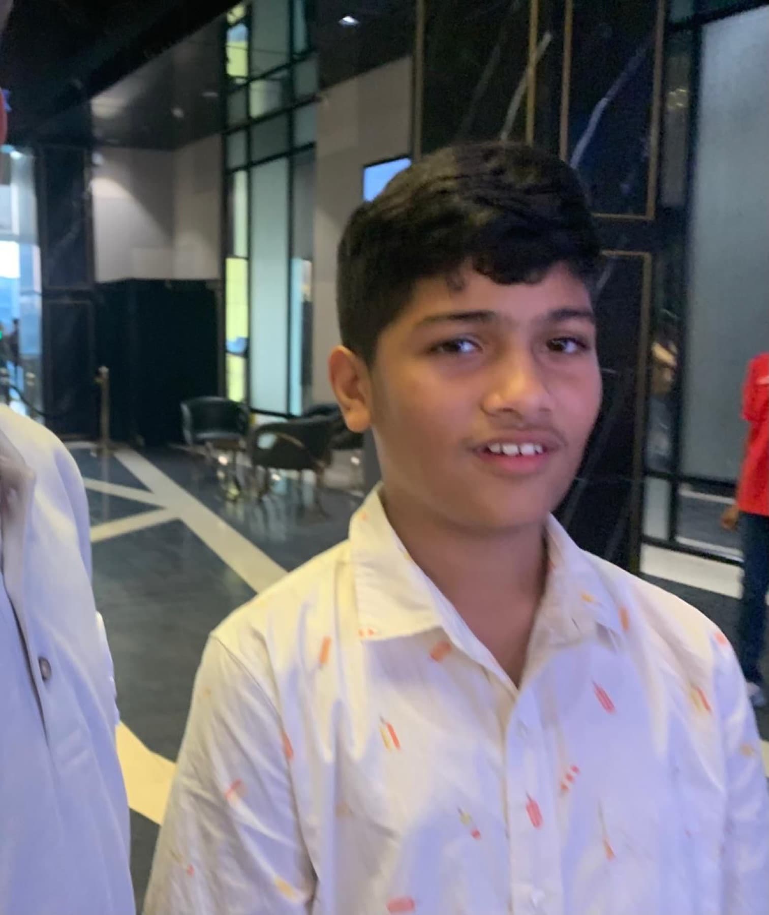 Darsh in a patterned shirt in a lobby